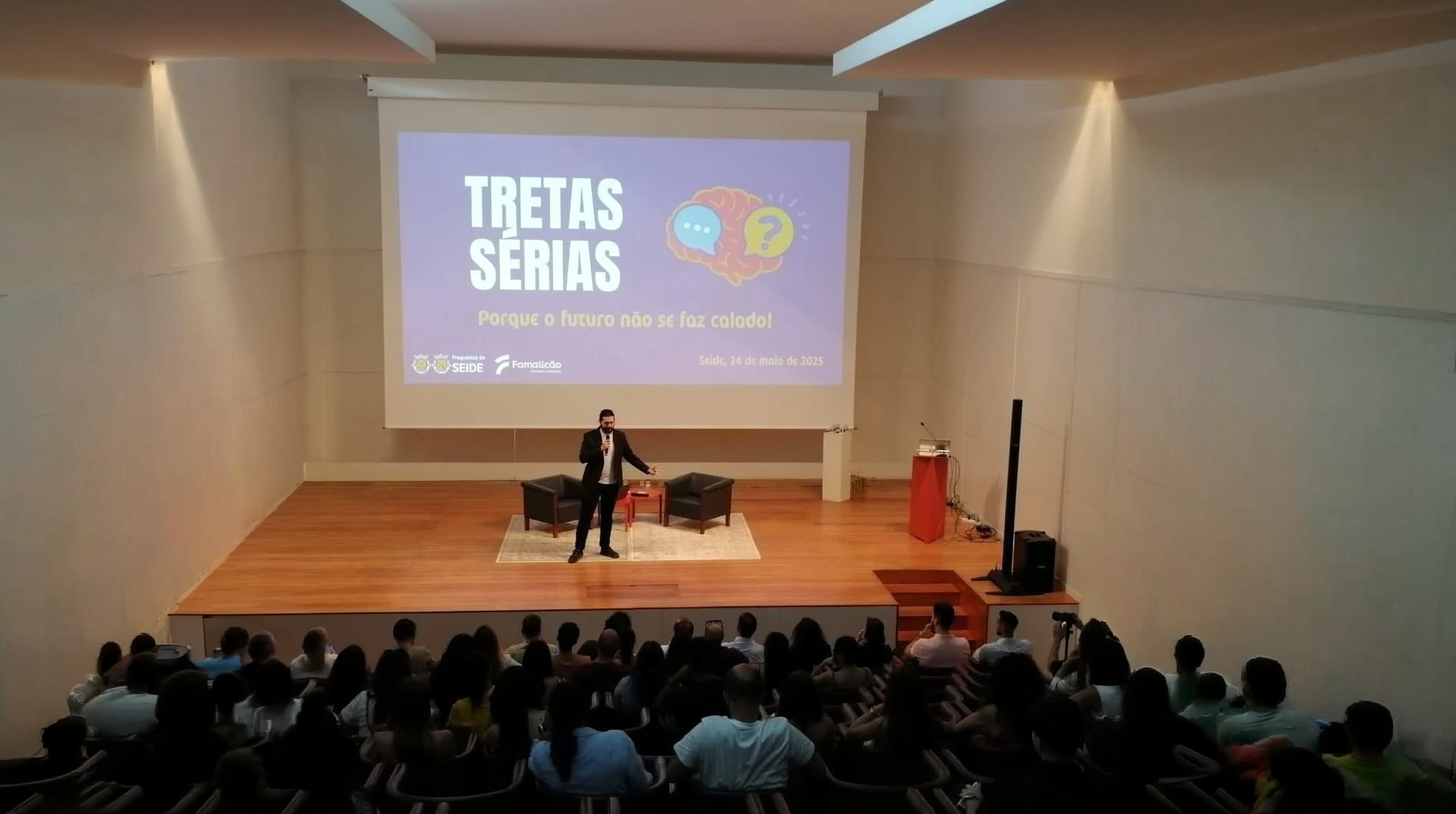 Ricardo Cardoso como apresentador de evento em palco.